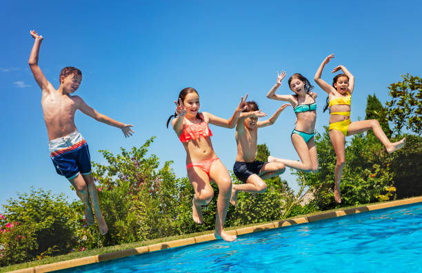 istock Fun in the pool group of kids jump inside water 1287445232
