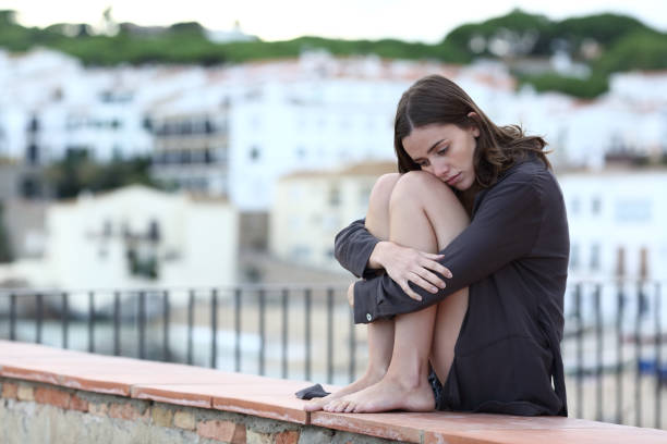 istock Sad teen complaining on a ledge in a beach town 1287445798