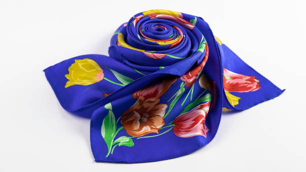 istock Isolated beautiful  bright  blue silk scarf with wonderful floral pattern folded nicely  is on the white background. 1287446668