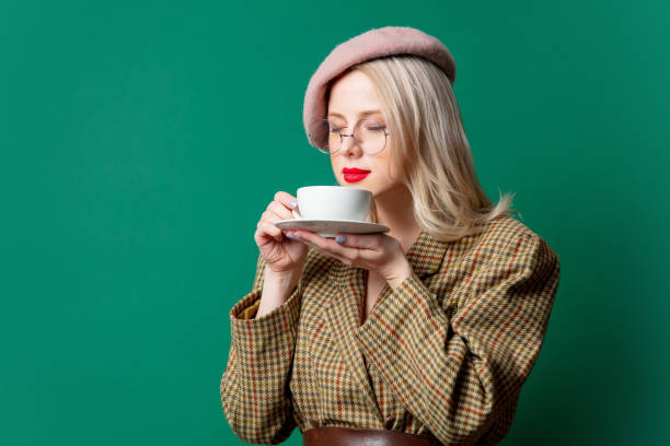 beautiful woman in style jacket and hat with cup