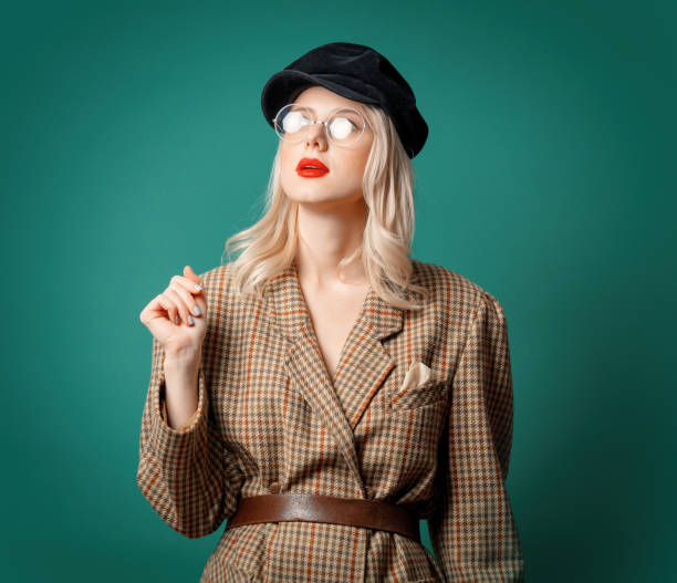istock woman in British style jacket and hat on green background 1287448359