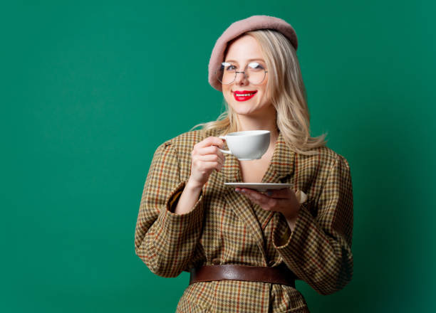 istock beautiful woman in style jacket and hat with cup 1287448369