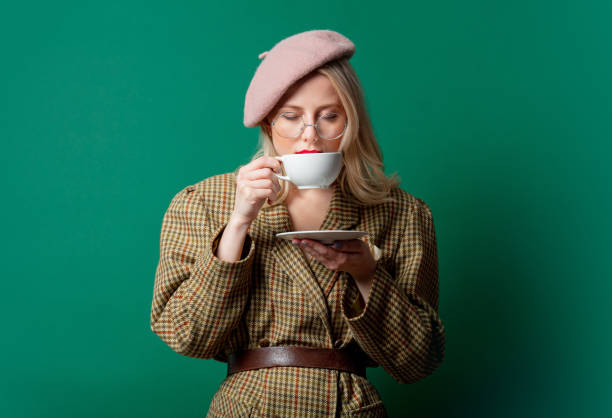 istock beautiful woman in style jacket and hat with cup 1287448371