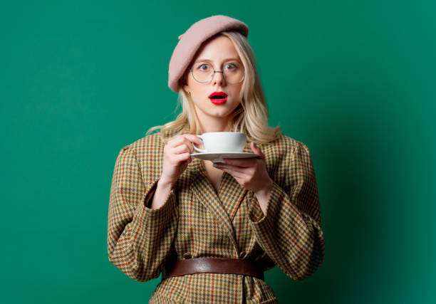 istock beautiful woman in style jacket and hat with cup 1287448383