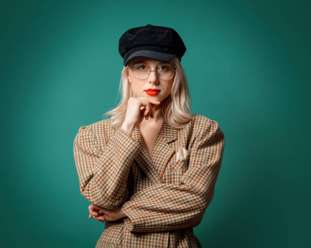 istock woman in British style jacket and hat on green background 1287448387