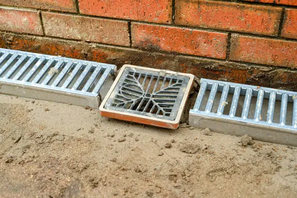 Photo of Metal drainage channels and drain laid for a garden patio