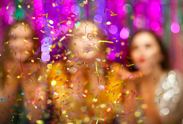 istock Cheerful women blowing Christmas confetti 1287449176
