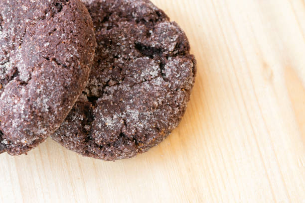 vista ravvicinata dei biscotti al cioccolato sul tavolo di legno. - biscotti cookie morning temptation foto e immagini stock