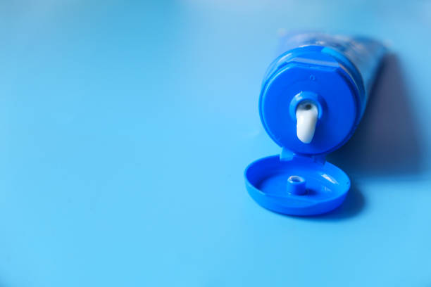 istock Close up of face cream in a container on blue background 1287451975