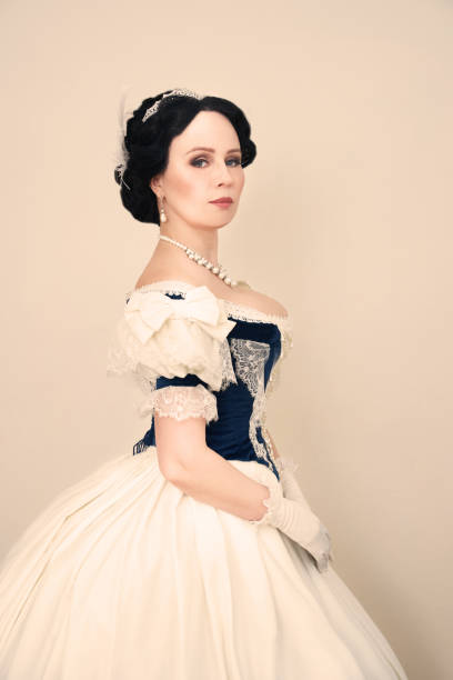 Beautiful elegant woman in a historical dress A beautiful elegant dark haired woman in a historic 1867 coronation dress on a white background looks at the camera duchess photos stock pictures, royalty-free photos & images