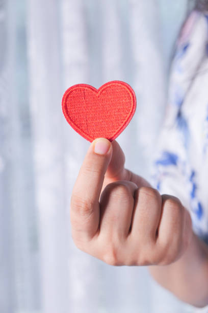 istock women holding red heart in hands close up 1287453070
