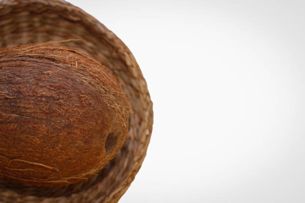 One Coconut In A Wicker Plate In Selective Focus. Isolated Image On A White Background With Copy Space.