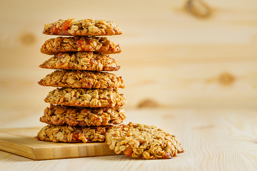 Delicious sweet oatmeal cookies on a wooden table.