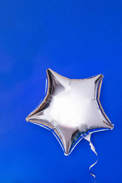istock A silver glitter foil star shaped balloon on blue 1287455130