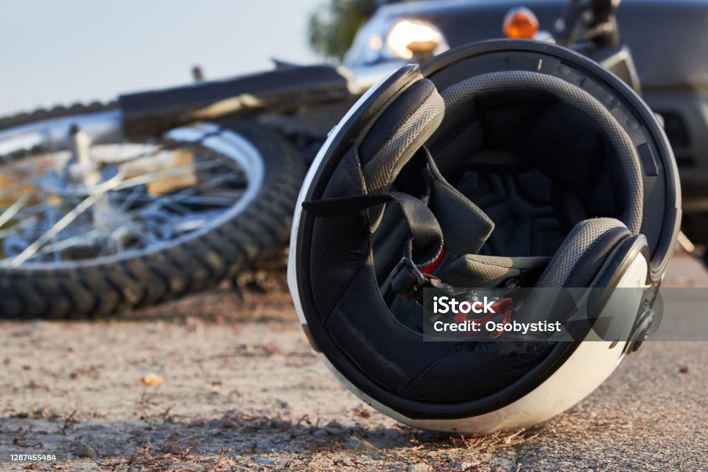 Photo of car, helmet and motorcycle on the road, the concept of road accidents. Photo of car, helmet and motorcycle on road, the concept of road accidents. Motorcycle Stock Photo