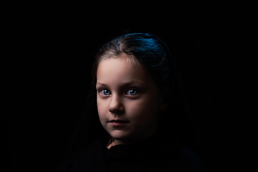 Black and white portrait of a girl’s face smiling, she is looking at the camera with love and feeling, with bright eyes and a polka dot headband.