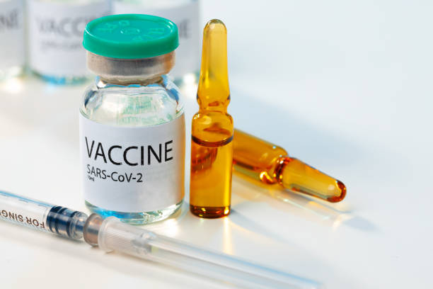 istock Sars-cov-2 vaccine vial and syringe on white table 1287459430