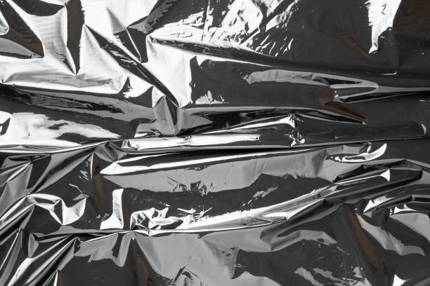 istock Plastic black background. Wrap transparent dark cellophane. Black shiny film bag pattern. Real texture of polyethylene foil. 1287462186