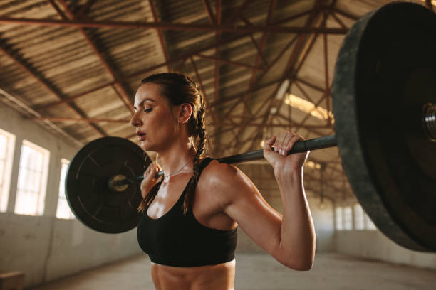 istock Fit woman exercising back squats with weights 1287462529