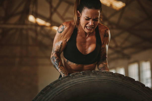 istock Strong woman performing tyre flipping workout 1287462571
