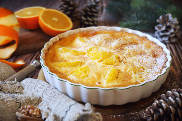 neujahrsdessert. orange clafoutis mit praline, puderzuckerdressing - clafoutis stock-fotos und bilder