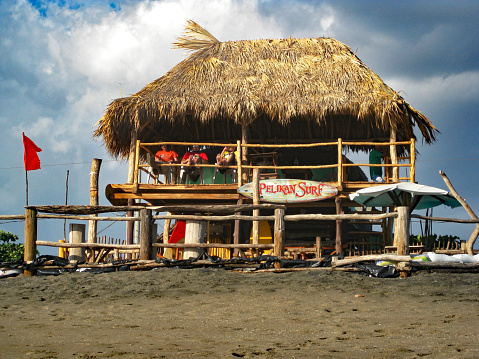 Las Penitas, Nicaragua, February 19th. 2012: Three Men Drinking  Beer in a Thatch Covered Surf Shop.