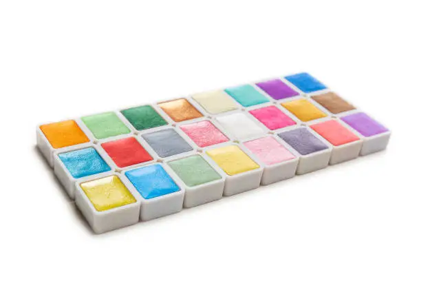 Watercolor Paint in Pans, clean and new isolated on white background. Vibrant pearlescent colors with copy space.