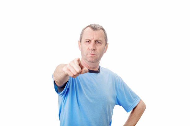 istock Angry young middle aged man pointing index finger showing to camera, like scolding someone, isolated over white background with copy space. 1287465726