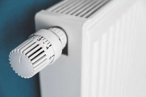 Close-up on thermostat valve of white radiator in home interior stock photo