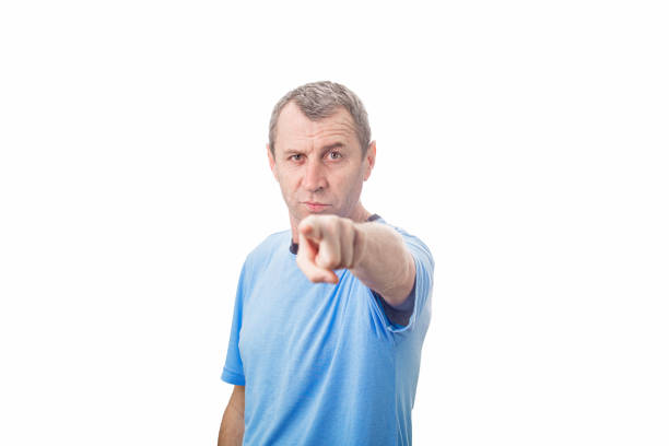 istock Angry young middle aged man pointing index finger showing to camera, like scolding someone, isolated over white background with copy space. 1287466533