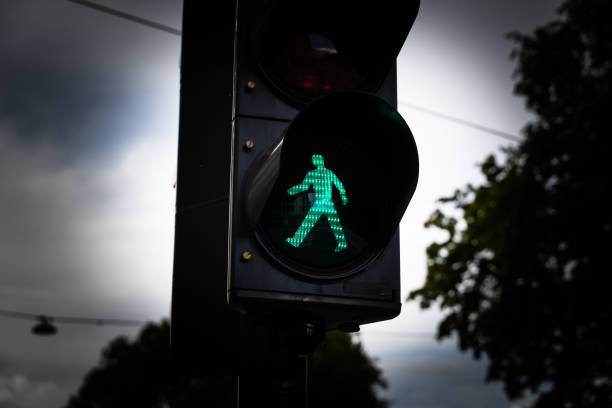 istock Green man walking traffic light at a city crosswalk. 1287466654