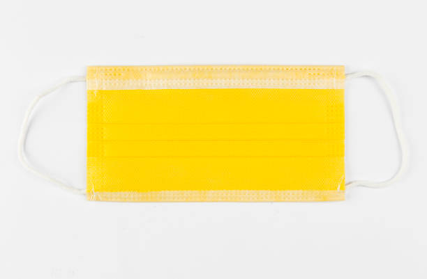 istock Yellow color medical protective face mask isolated on white background. 1287467140