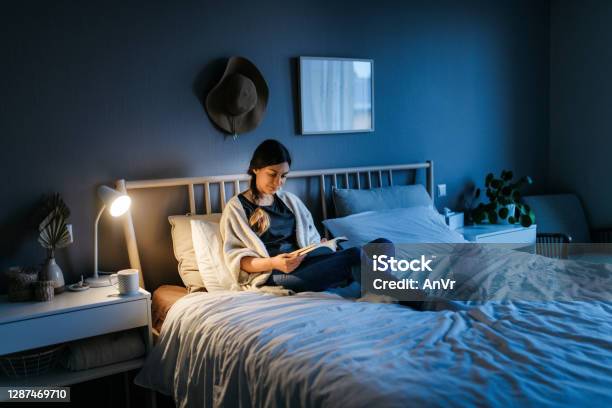 Woman Reading A Book At Night Stock Photo - Download Image Now - Reading, Bed - Furniture, Night