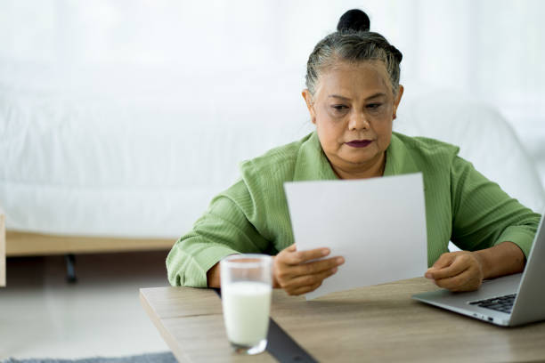 istock Senior retired Asian woman work from home with notebook computer new normal 1287470511