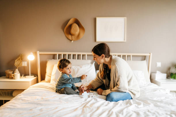 istock Mother and son playing on the bed 1287470700