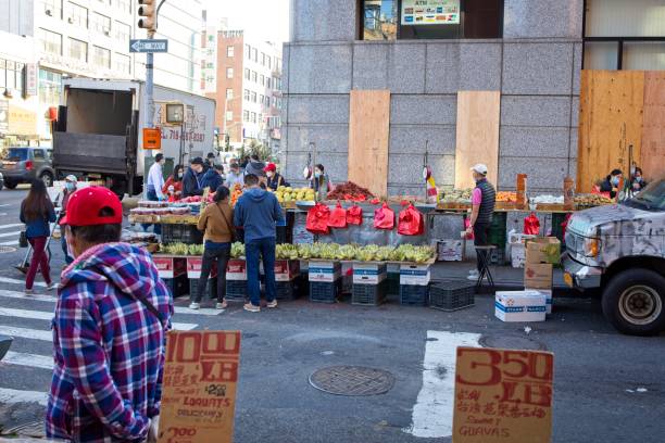 New York, NY, USA - Nov 24, 2020: Prices of fresh fruit along with people shopping at Canal and Mulberry Street