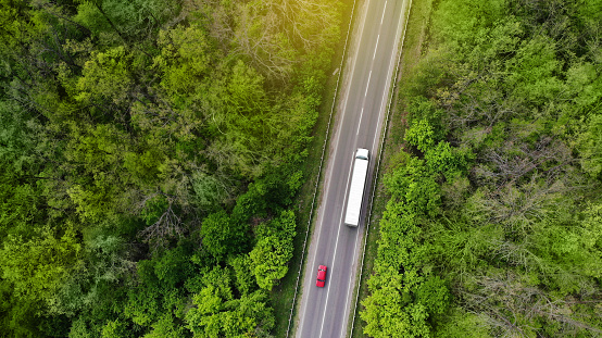 Aerial. Wagon driving by the highway. Transport logistics background. Top view from drone.