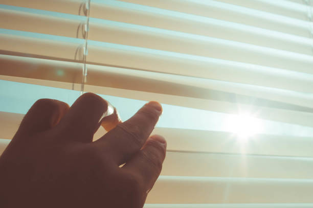 istock The sun shines through the half-open blinds on the window. 1287473780