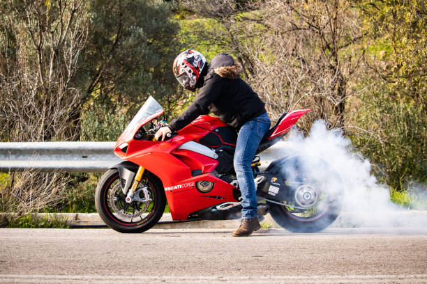 un hombre está quemando su neumático de moto - motorcycle engine brake wheel fotografías e imágenes de stock