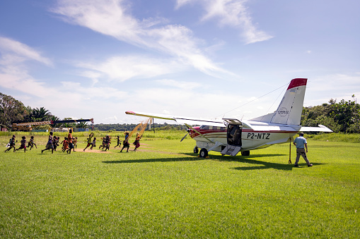 Village residents run to greet passengers on a Quest Kodiak 100, a plane operated by Ethnos360 Aviation, moments after it arrives at the bush airstrip in Tamo (Likan) in the East Sepik Province of Papua New Guinea on June 20, 2019.