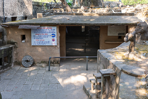 Chandigarh / India - November 20, 2020 : The location of hut from where great artist Mr. Nek Chand made modest beginnings of his immortal masterpiece Rock Garden. Notice for visitors with Covid-19 safety guidelines put on the wall.