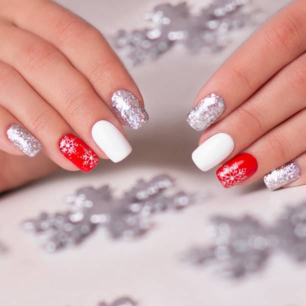 Female hands with winter manicure nails Beautiful female hands with winter manicure nails, red and silver gel polish, Christmas design christmas nails stock pictures, royalty-free photos & images