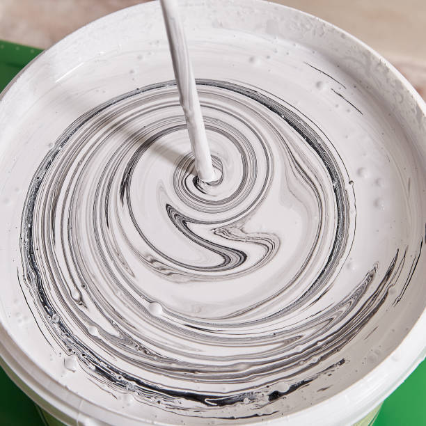 istock Handyman is mixing paints in basket using drill to paint walls. 1287486293