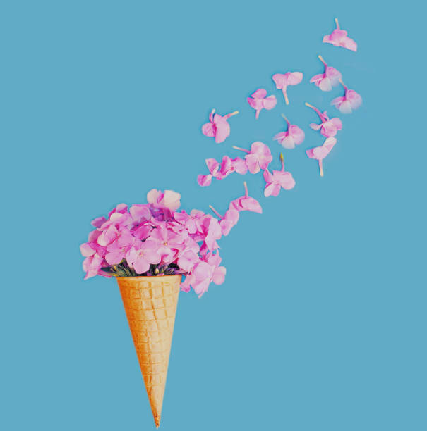 istock Cone with pink flowers as ice cream over a blue background 1287487833