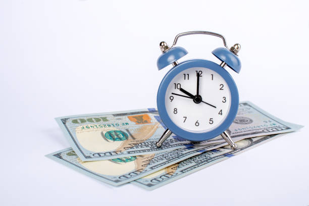 istock Clock and money isolated on white background. Time is money concept. Template for design. Copy space. 1287487838