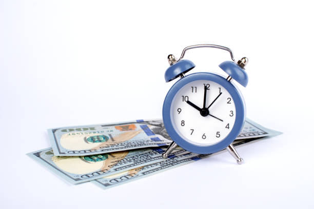 istock Clock and money isolated on white background. Time is money concept. Template for design. Copy space. 1287487930