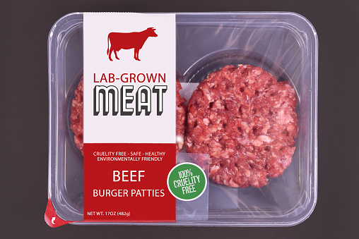 Lab grown cultured meat concept for artificial in vitro cell culture meat production with packed raw burger patties with made up label on dark background