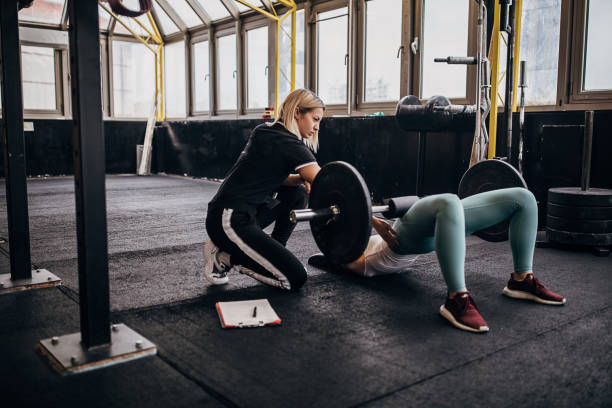 istock Female personal trainer assisting her student train 1287490231