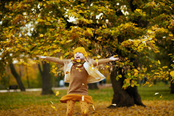 istock smiling young child in brown sweater and orange hat rejoicing 1287490390