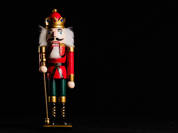 istock NUTCRACKER DOLL ON BLACK BACKGROUND WITH GREEN PATALON AND RED JACKET 1287490400